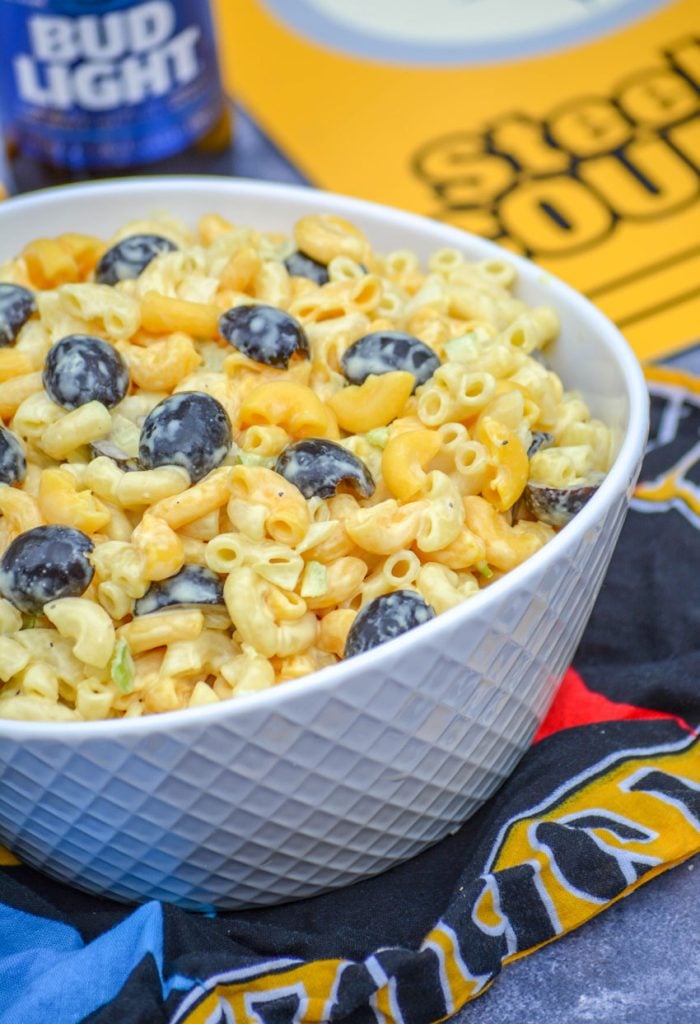pittsburgh steelers themed pasta salad served in a white bowl with a bottle of beer and team paraphernalia in the background 