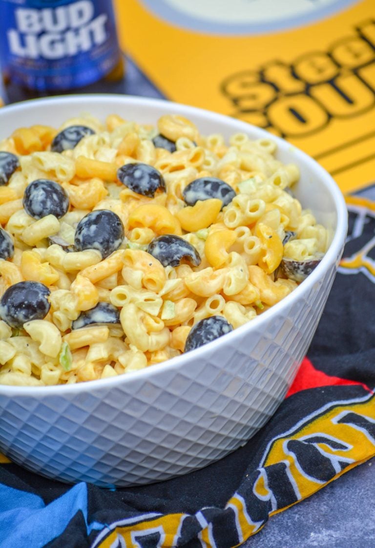 pittsburgh steelers themed pasta salad served in a white bowl with a bottle of beer and team paraphernalia in the background