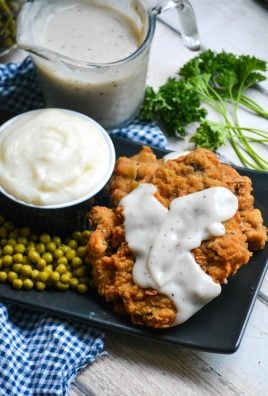 country fried steak with pepper gravy served on a black plate