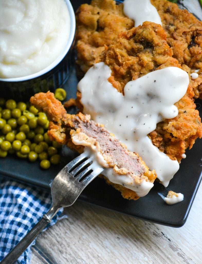 country fried steak with gravy served on a black plate