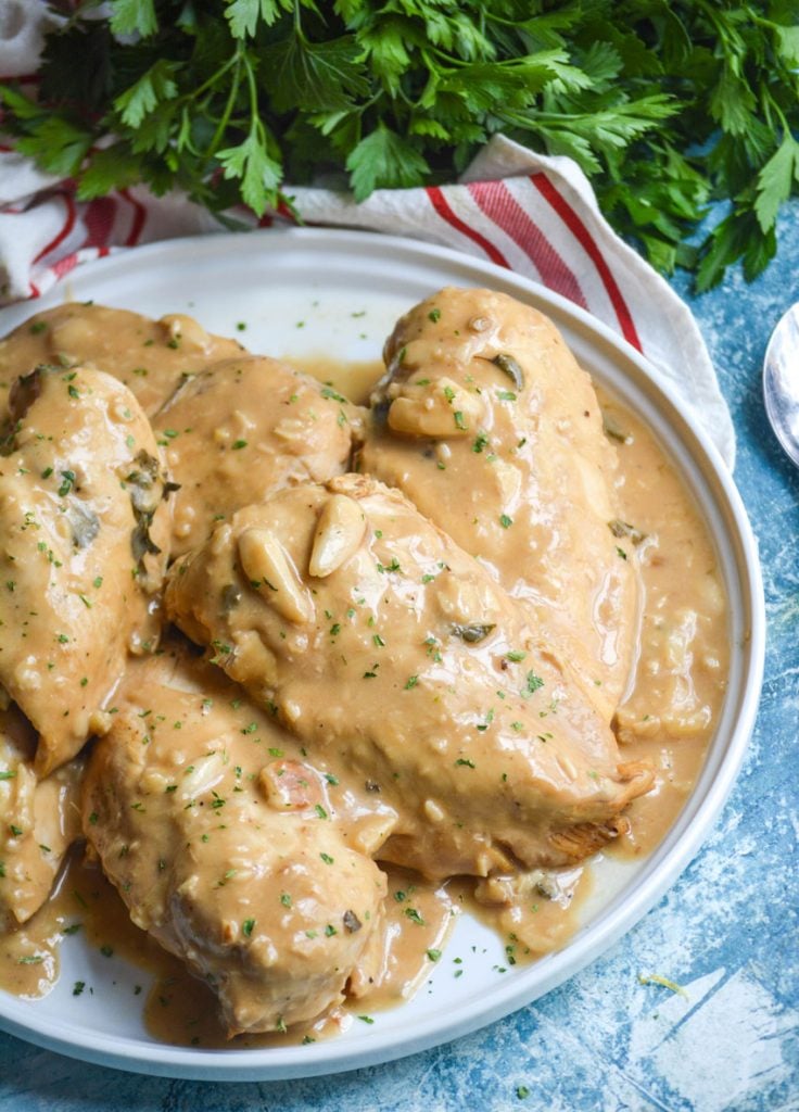 sauce laden Instant pot 40 cloves of garlic chicken served on a white plate