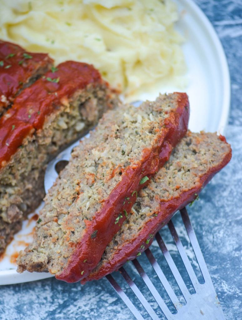 a silver spatula holding two slices of Instant pot meatloaf
