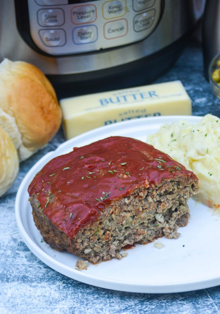 Instant pot meat loaf and whipped mashed potatoes served on a white plate