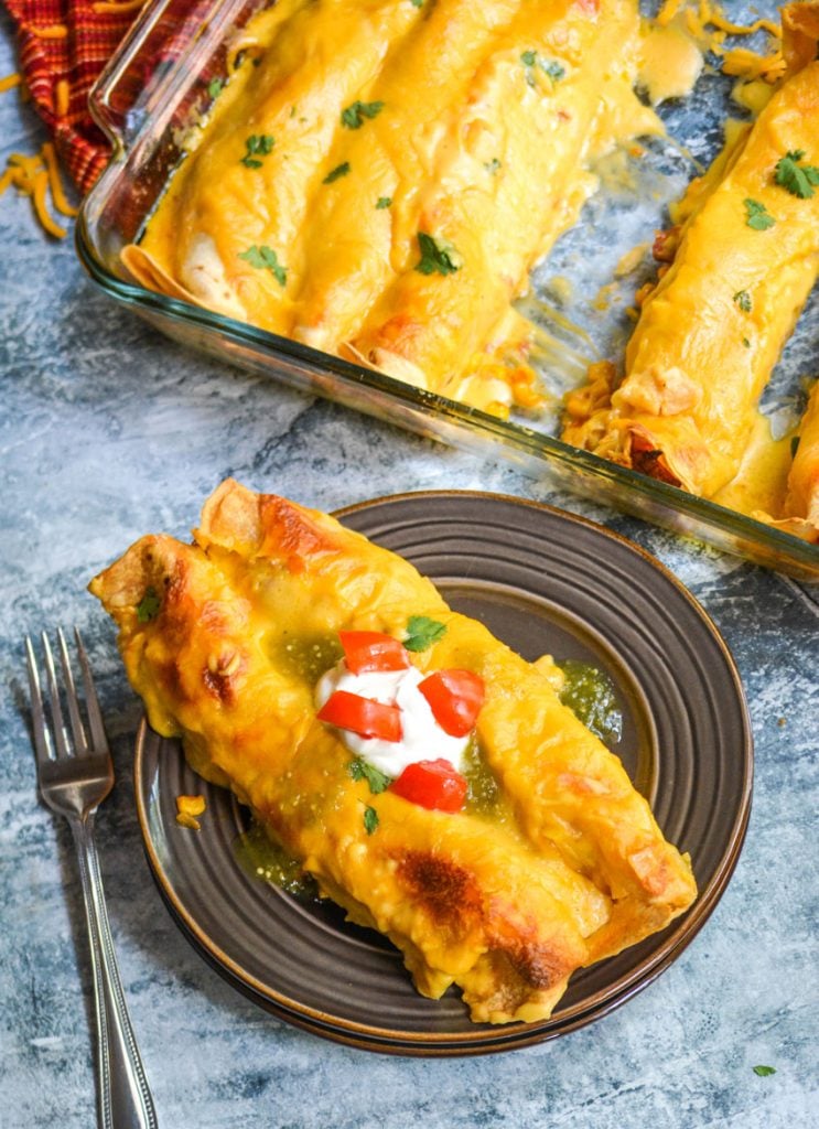 cheesy pulled pork enchiladas on a brown plate