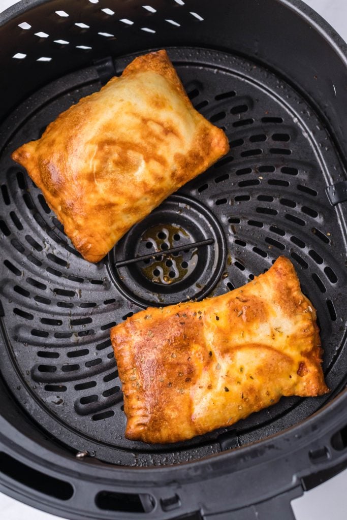 air fried hot pockets shown crisp & golden brown in a black air fryer basket