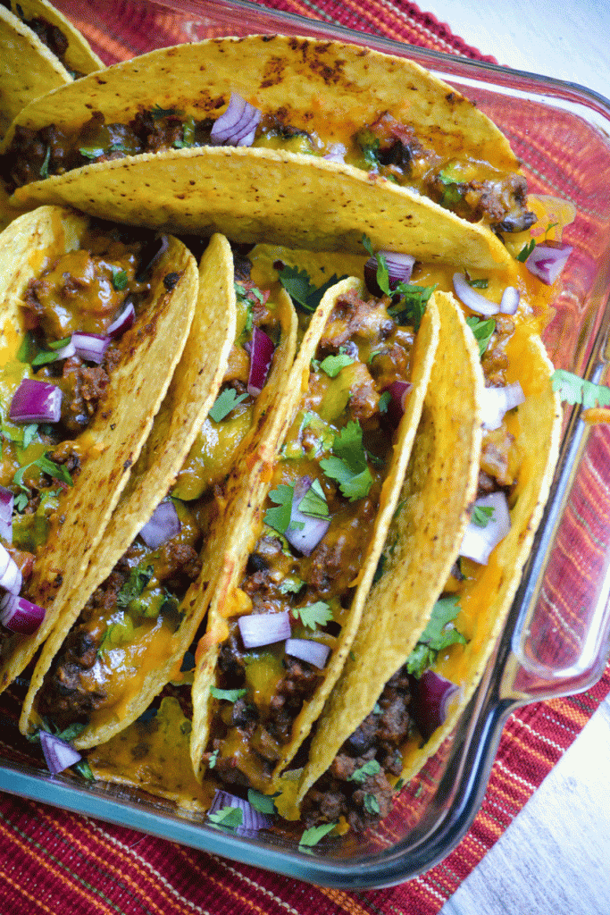 oven baked tacos lined up in a baking dish