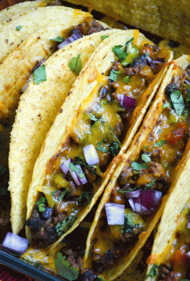 oven baked tacos lined up in a baking dish