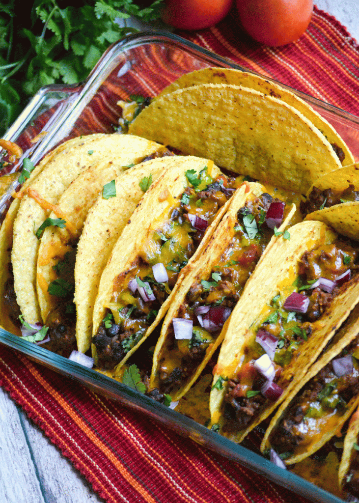 oven baked tacos lined up in a baking dish