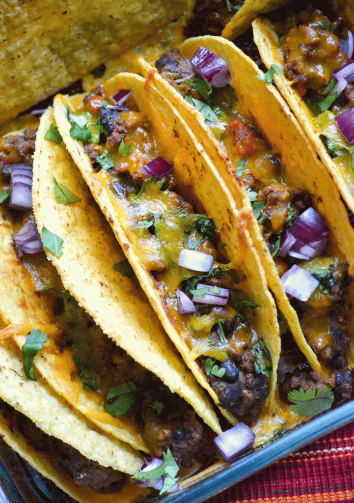 oven baked tacos lined up in a baking dish