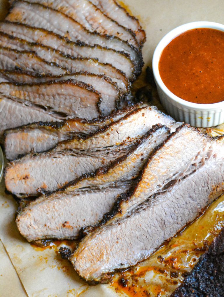 slices of juicy smoked brisket arrayed on a wooden cutting board