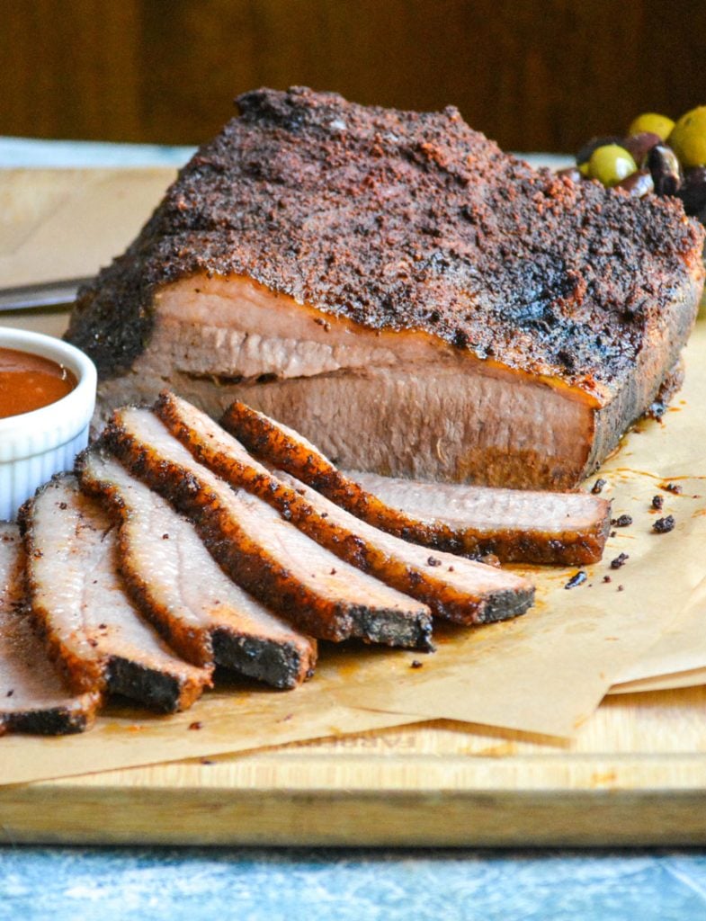 slices of juicy smoked brisket arrayed on a wooden cutting board