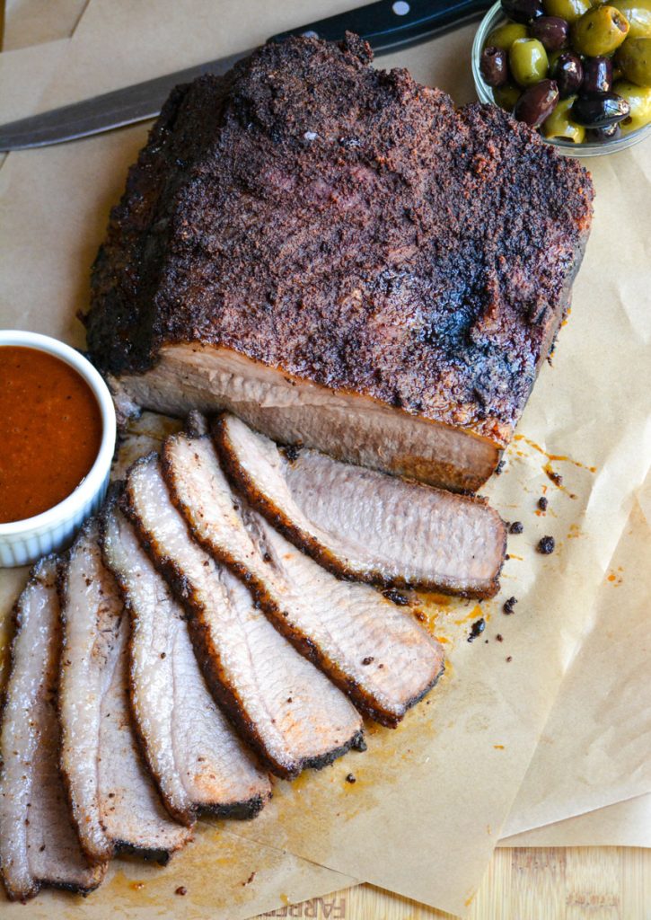 slices of juicy smoked brisket arrayed on a wooden cutting board