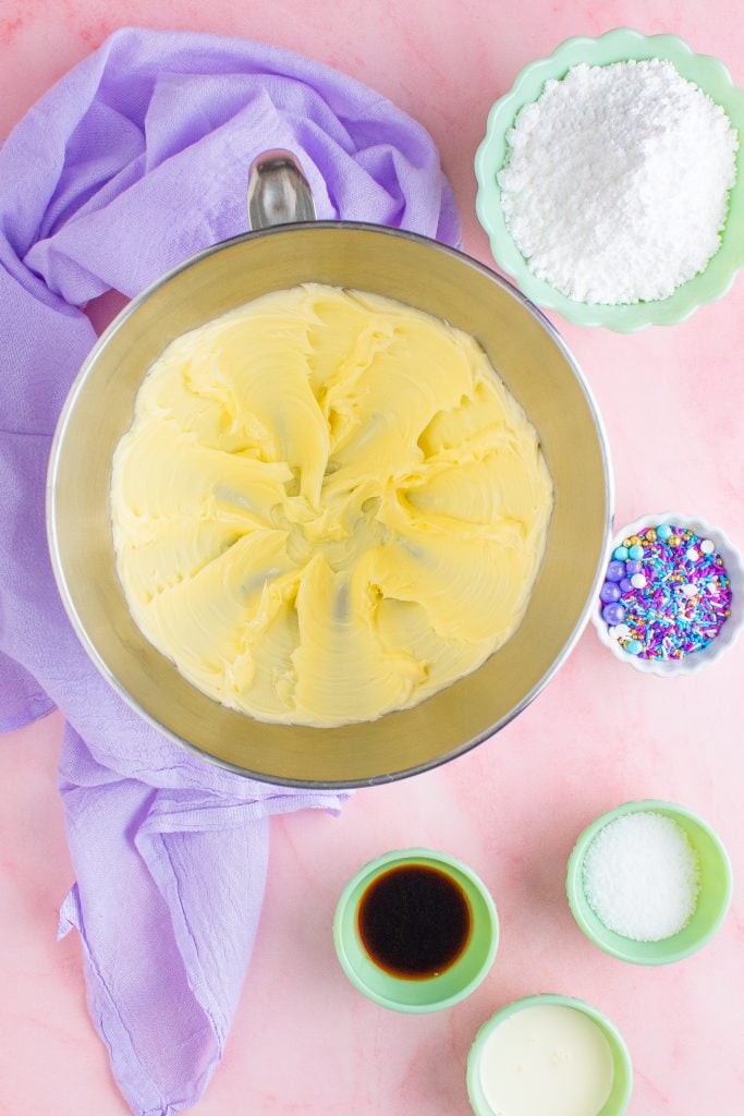 cake decorating frosting being shown mixed together in the bowl of a stand mixer