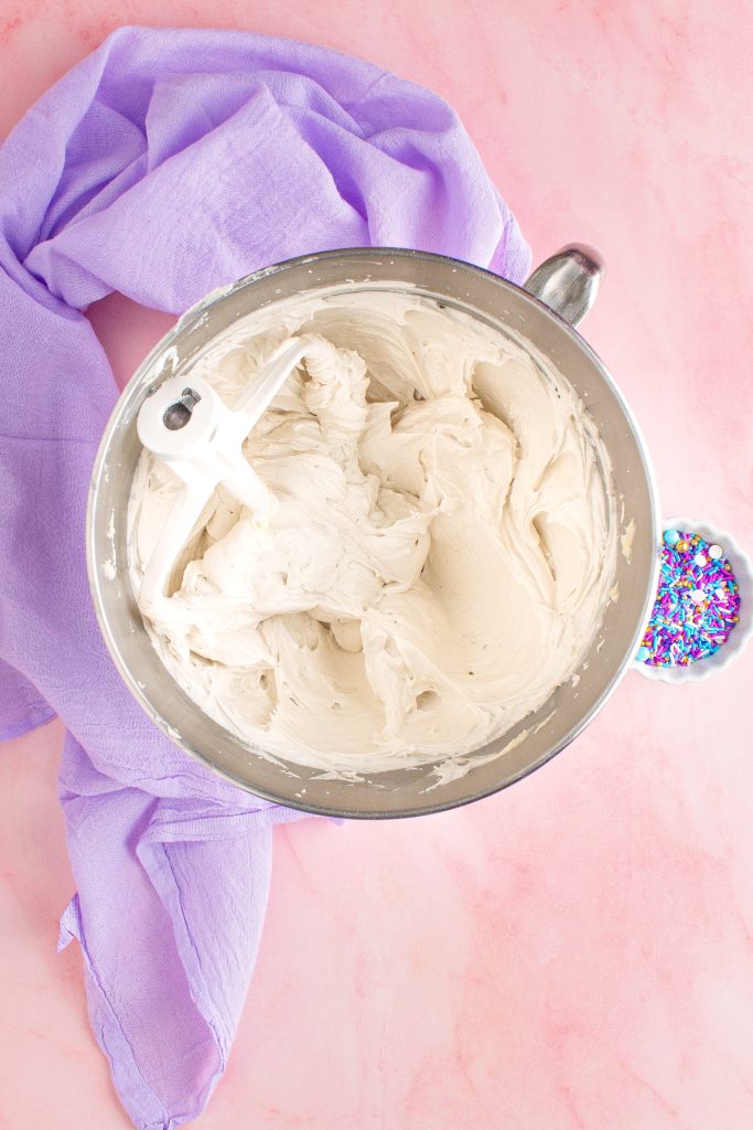 cake decorating frosting being shown mixed together in the bowl of a stand mixer