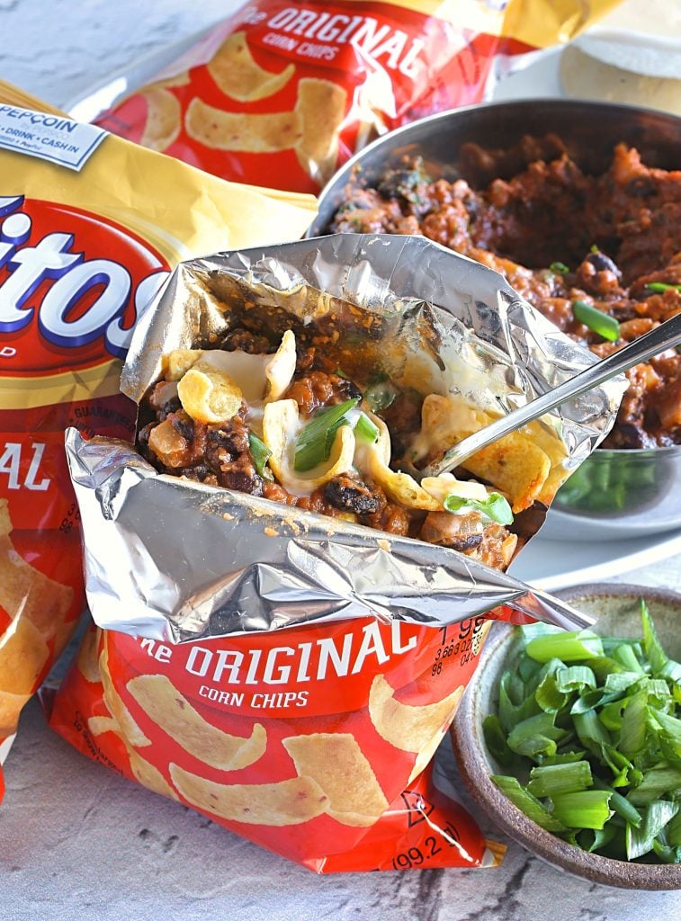a walking taco bag shown split open with a long silver spoon sticking out