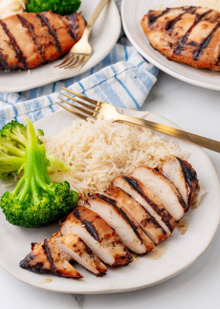 a grilled teriyaki chicken breast with white rice and steamed broccoli on a white plate