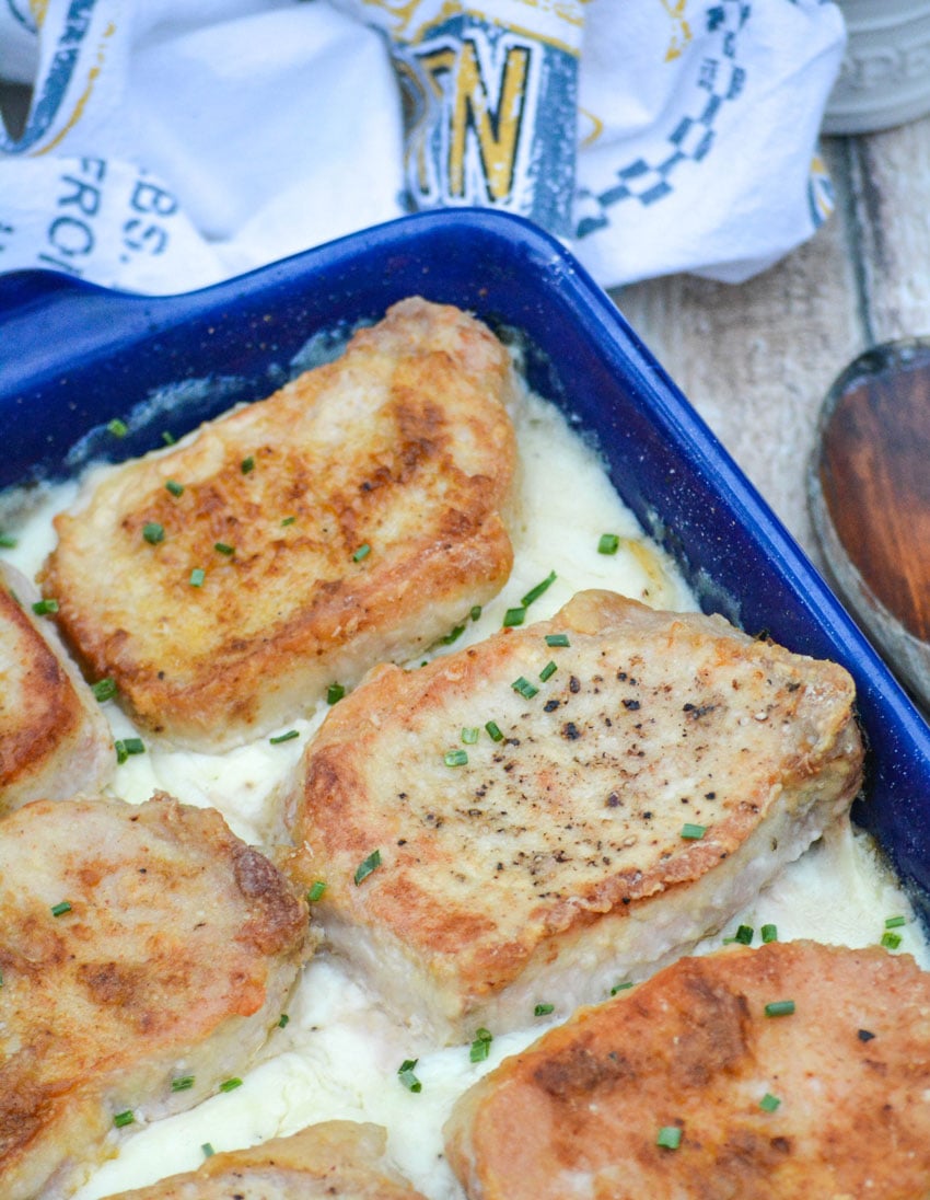 farmer's pork chops and potatoes served in a blue casserole dish