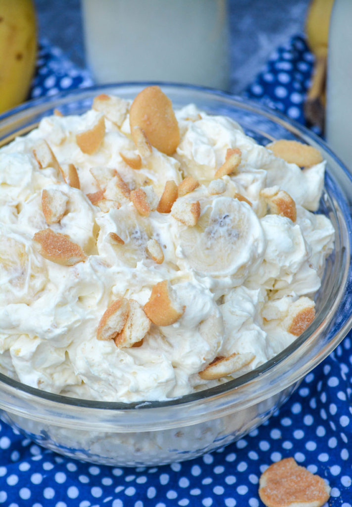 banana pudding fluff salad shown in a glass pyrex bowl topped with chopped vanilla wafers cookies