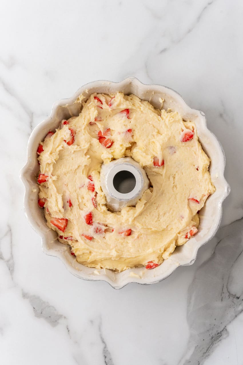 strawberry lemon yogurt cake batter in a greased bundt pan