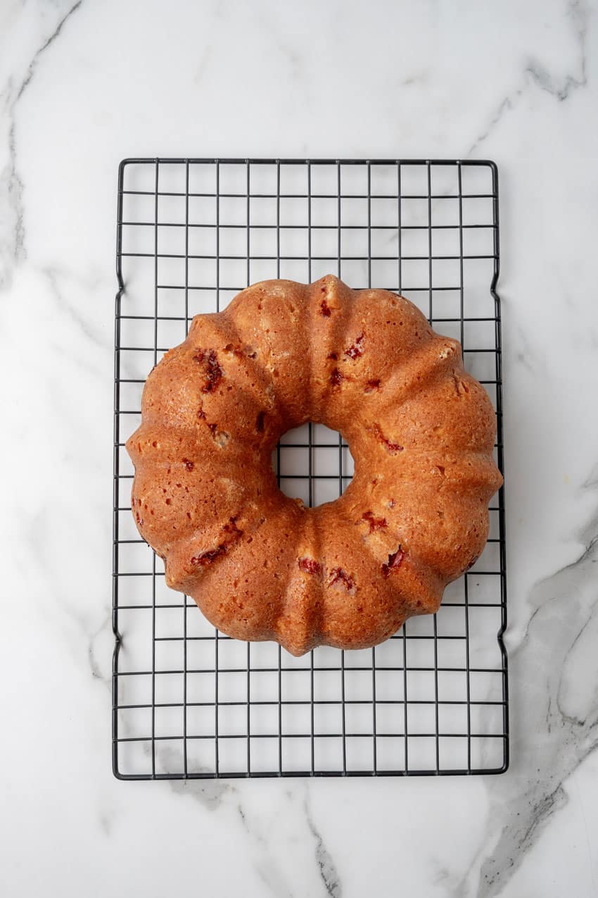 a baked strawberry lemon yogurt cake turned out on a wire baking rack to cool