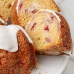 slices of strawberry lemon yogurt cake on a white cake stand