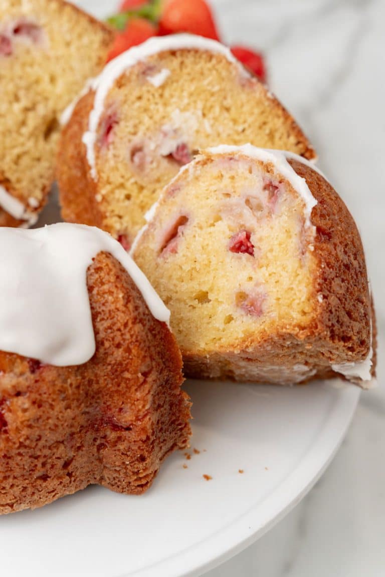 slices of strawberry lemon yogurt cake on a white cake stand