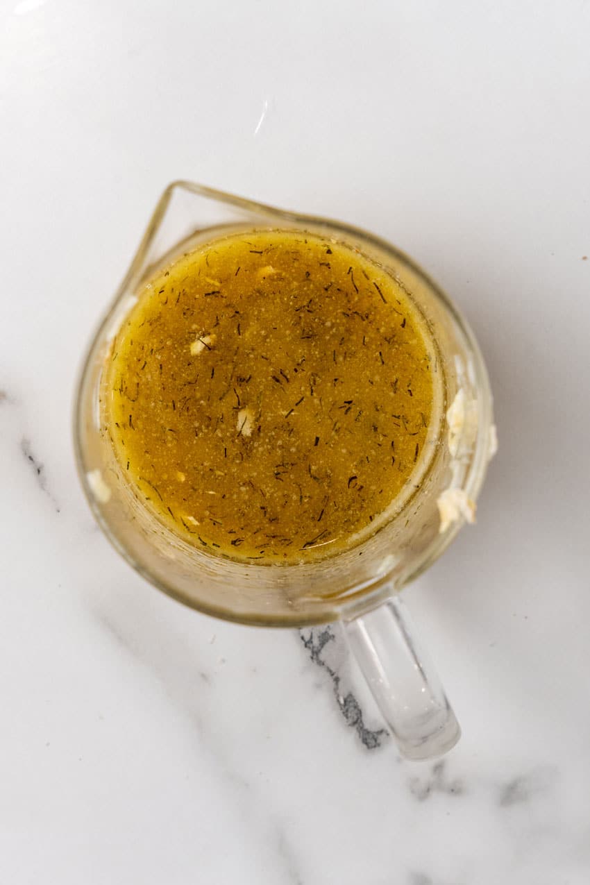 herbed melted butter mixture in a glass measuring cup