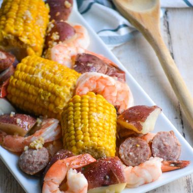 a white rectangular plate showing instant pot shrimp boil on a wooden table top