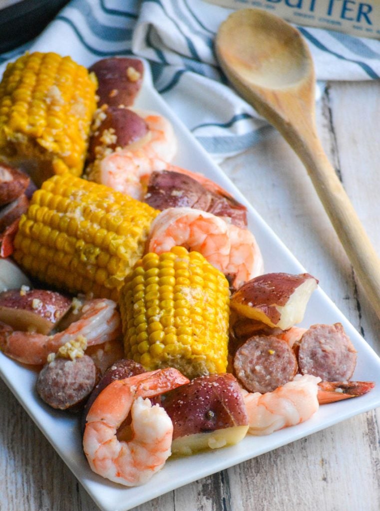 a white rectangular plate showing instant pot shrimp boil on a wooden table top