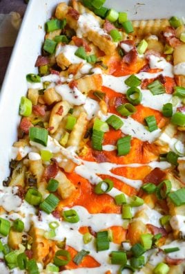 a batch of loaded buffalo cheese fries in a white casserole dish