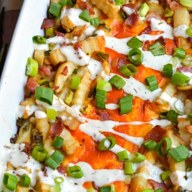 a batch of loaded buffalo cheese fries in a white casserole dish