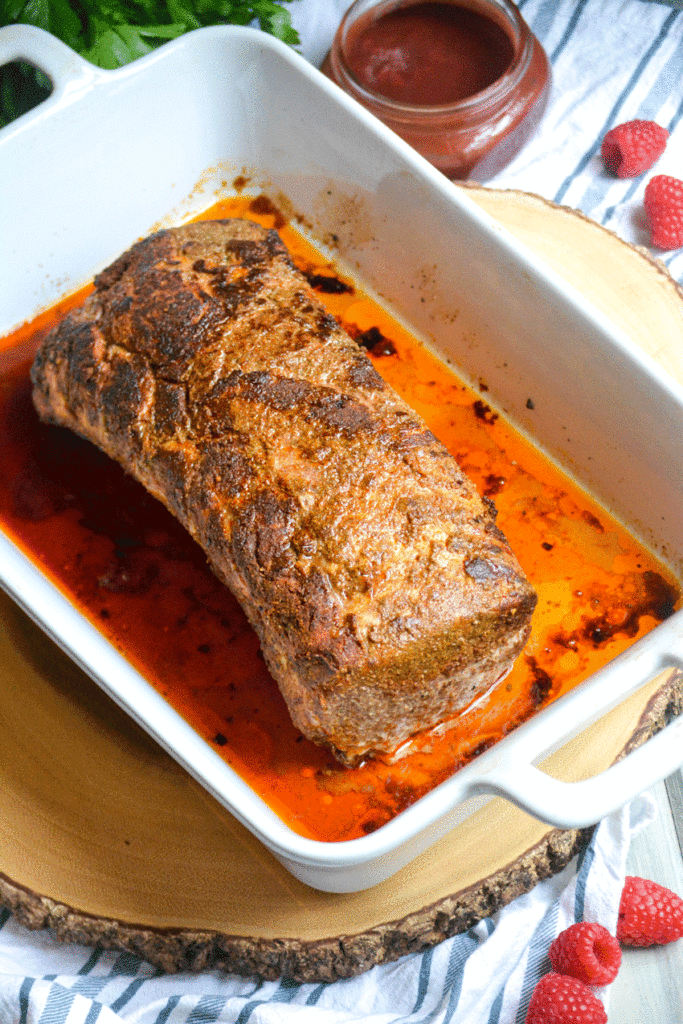oven baked pork loin shown in a white casserole dish
