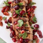 chipotle tenderloin topped with fresh cherry and cilantro salsa shown on a large white platter