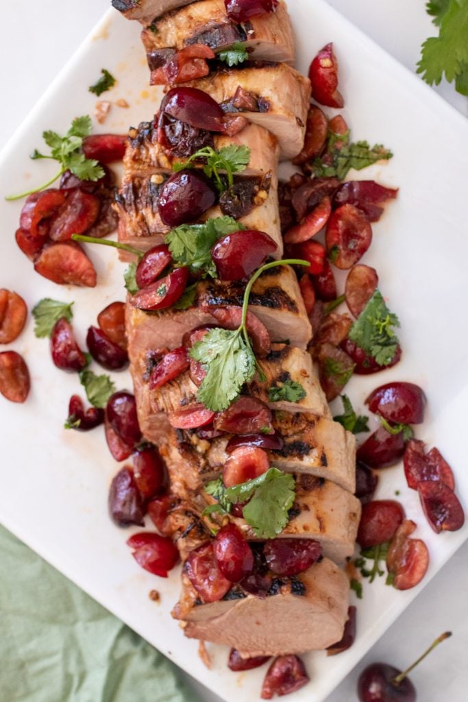 chipotle tenderloin topped with fresh cherry and cilantro salsa shown on a large white platter