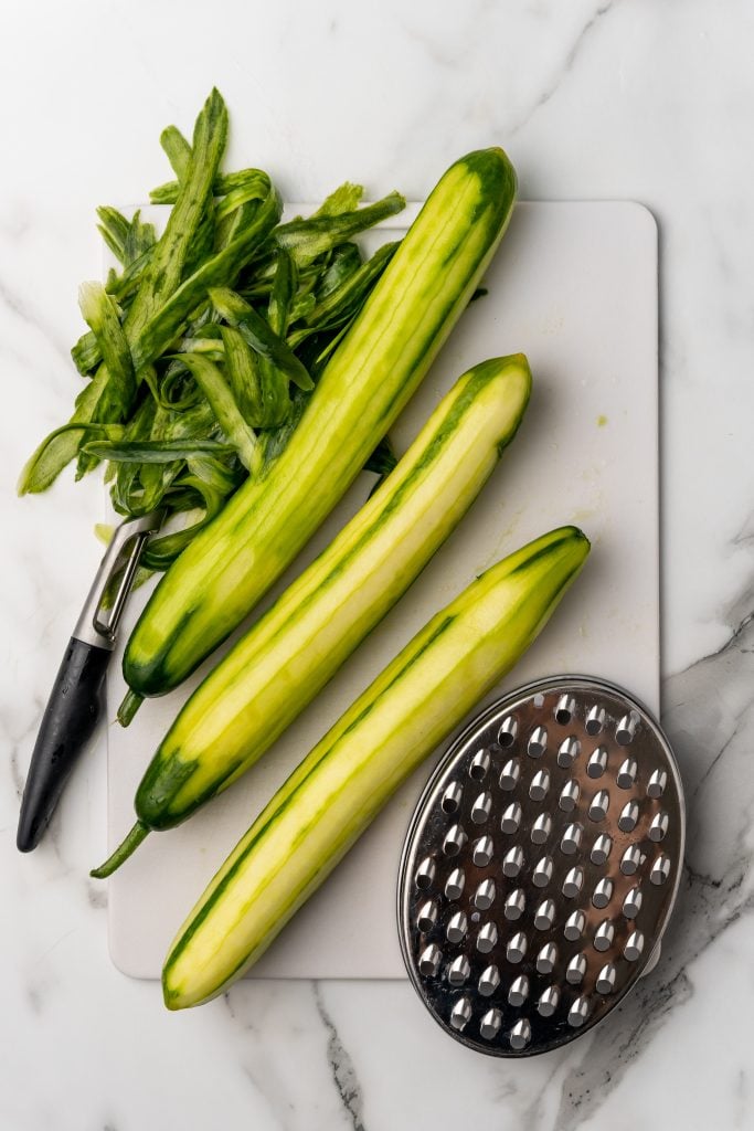 peeled cucumbers on a white cutting board