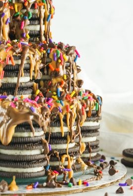 tiktok oreo tower cake covered in creamy peanut butter and rich nutella drizzles with rainbow sprinkles