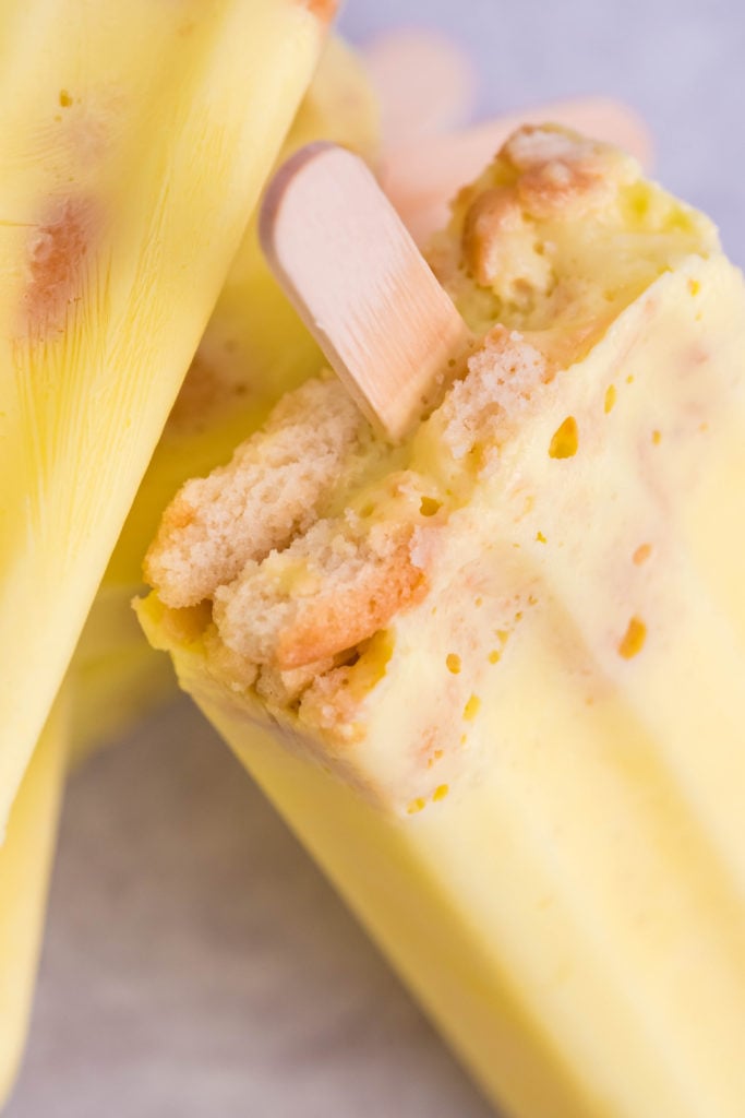 banana pudding popsicles with a nilla wafer crust and wooden stick in the bottom