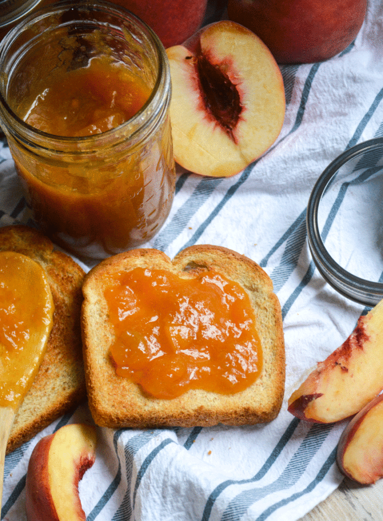 Instant Pot peach jam shown spread on a piece of toast