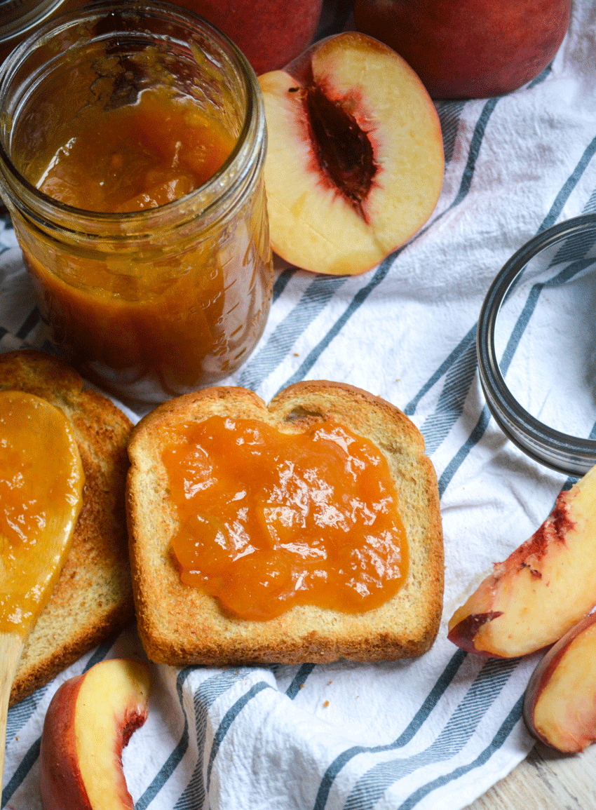 Instant Pot peach jam shown spread on a piece of toast