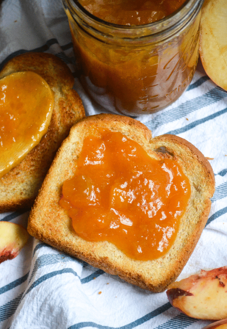 Instant Pot peach jam shown spread on a piece of toast