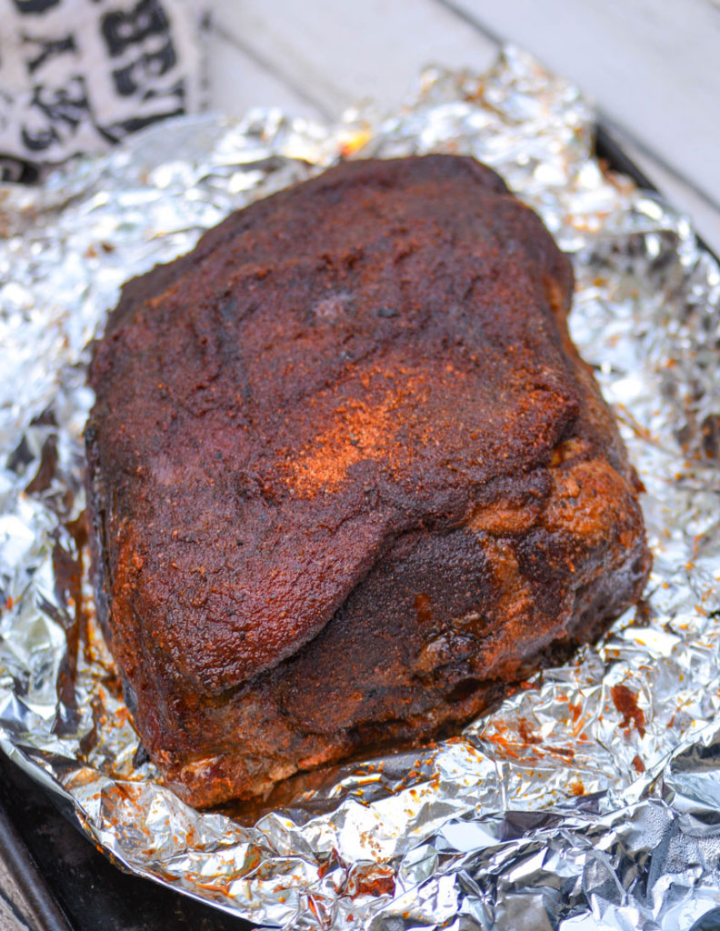 smoked pork shoulder shown on a piece of wrinkled aluminum foil