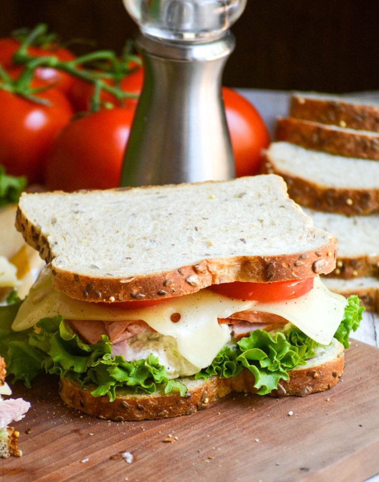 Chicken Club Sandwich Virginia Style shown on a wooden cutting board