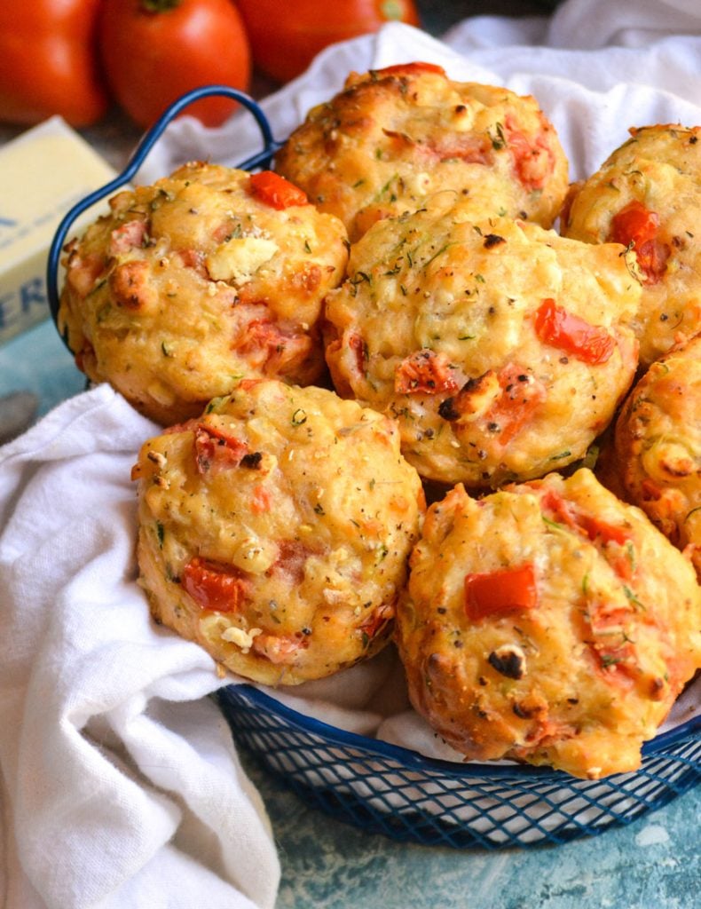 tomato zucchini feta muffins in a blue wire basket lined with white cloth