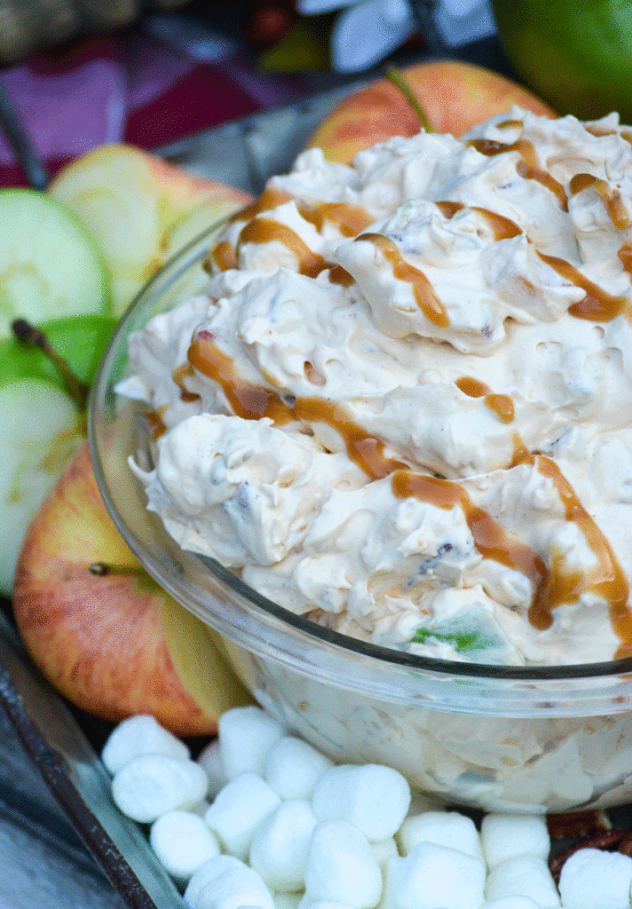 caramel apple fluff salad in a glass serving bowl drizzled with caramel syrup
