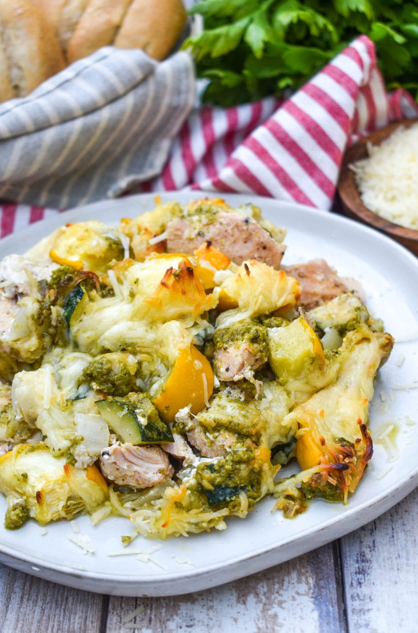 cheesy pesto chicken and squash casserole served on a white dinner plate