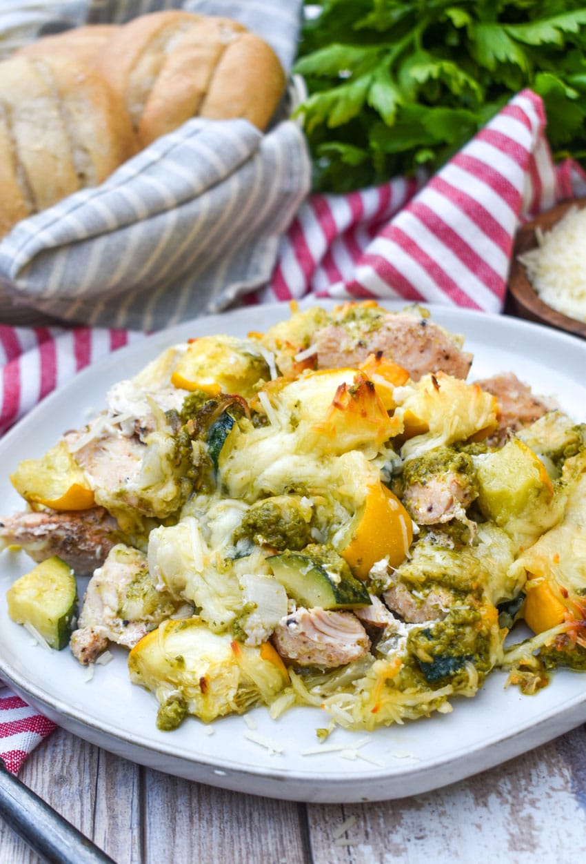 cheesy pesto chicken and squash casserole served on a white dinner plate