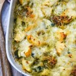 cheesy pesto chicken bake with squash on a white casserole dish