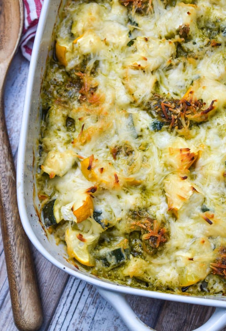 cheesy pesto chicken bake with squash on a white casserole dish
