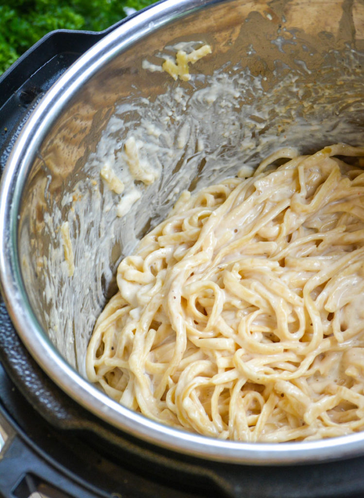 the bowl of an Instant Pot shown full of creamy alfredo pasta noodles