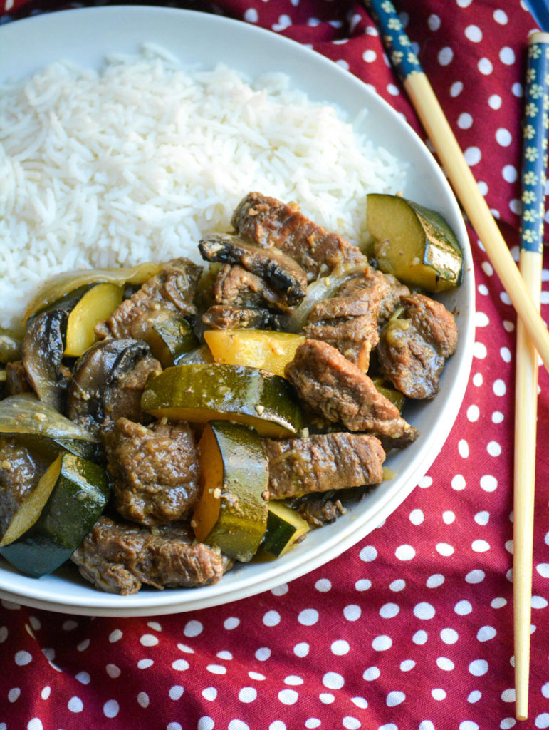 Instant Pot hibachi style steak & zucchini served with steamed white rice in a shallow white bowl
